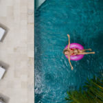 žena na ružovom nafukovacom kolese v bazéne